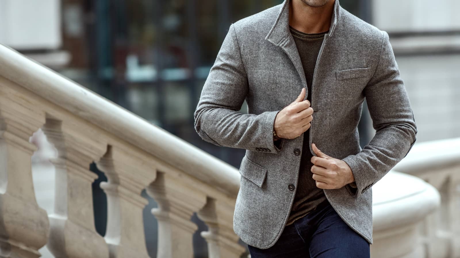 Mann mit Herbst-Outfit und grauem Sakko auf Treppe