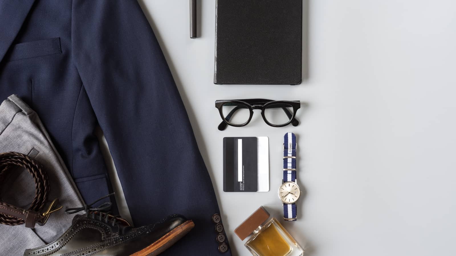 Herren Business-Outfit und Accessoires auf grauem Hintergrund